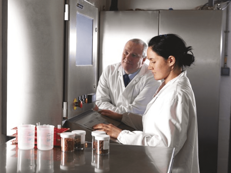 laboranci ubrani w białe kitle badający jakość karmy